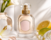 Frasco de perfume de vidro com flores brancas, limão e lima ao redor, em composição luminosa